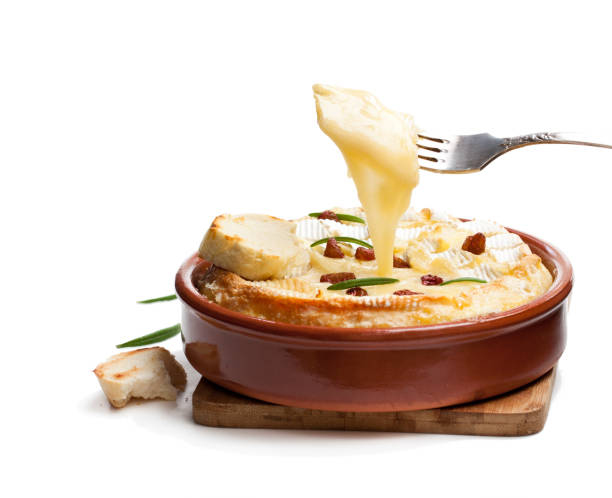 delicious hot baked camembert avec raisins secs sultanines isolées sur blanc - fondue fork photos et images de collection