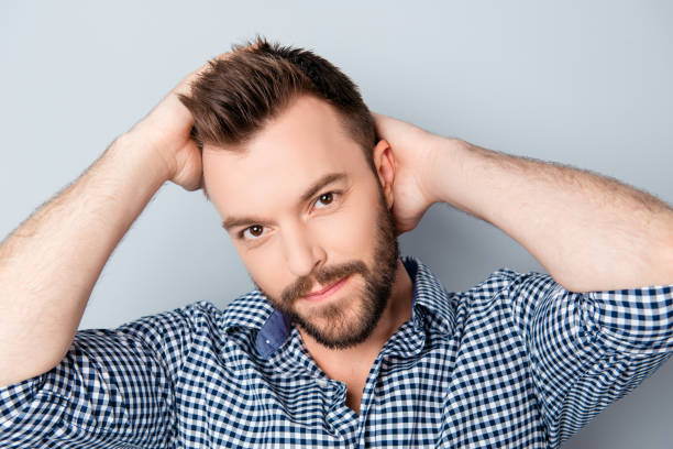istock Handsome smiling man holding hands on his hair 951018304