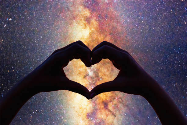 istock Silhouette heart shape hands with milky way in the night sky background. 951021656