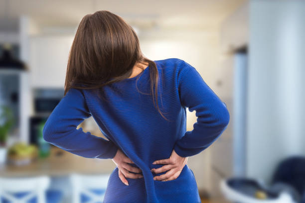腰痛の苦しみを持つ若い女性 - low back ストックフォトと画像