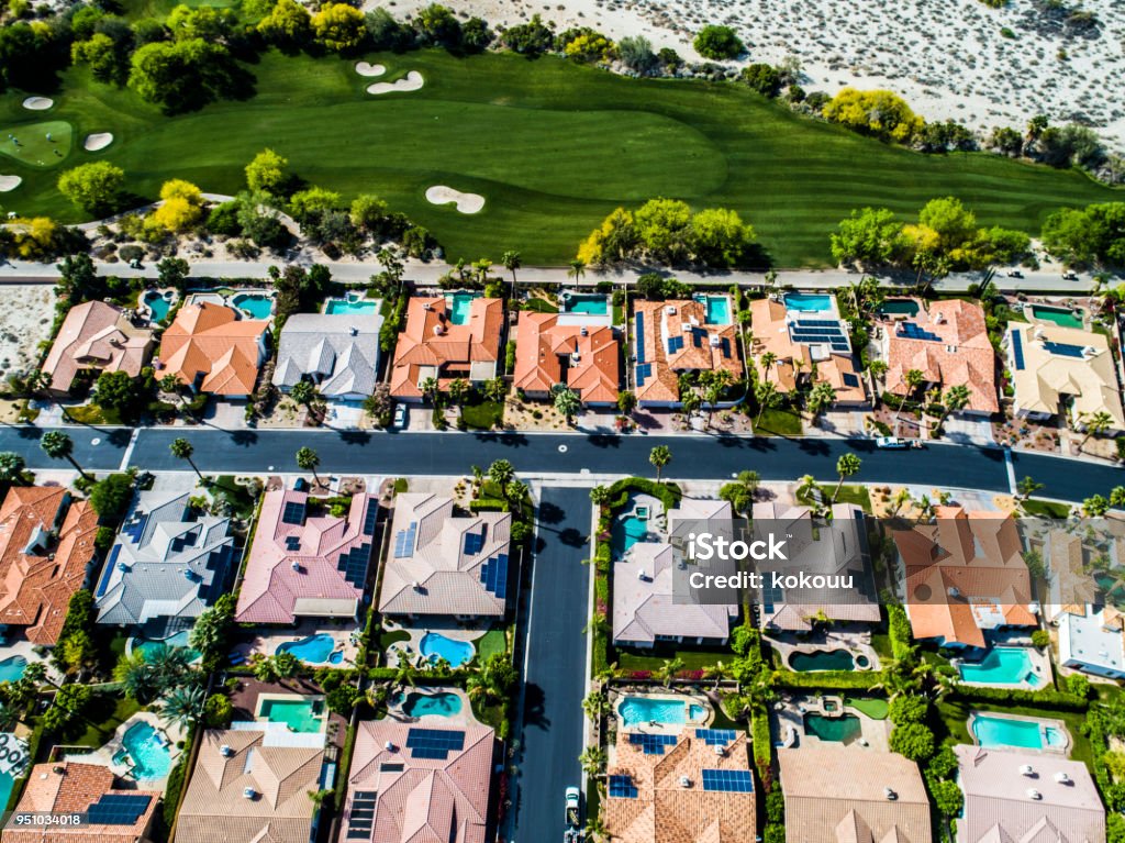 A row of houses with golf courses and pools. There is a pool next to the golf course and it is lining up. Golf Course Stock Photo
