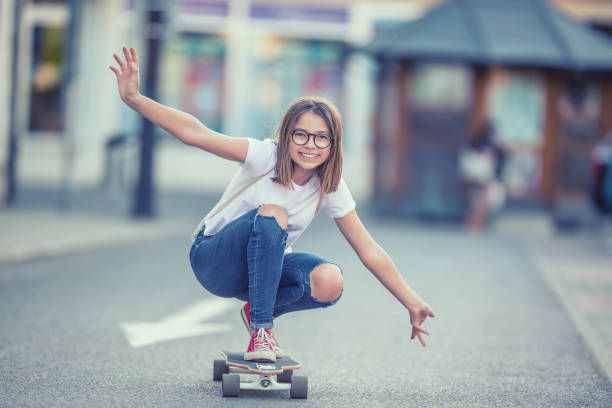 cut młoda łyżwiarka dziewczyna jazda na jej longboard w mieście - skateboarding skateboard teenager child zdjęcia i obrazy z banku zdjęć