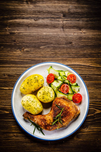 istock Roast chicken leg with boiled potatoes and vegetable salad 951038074