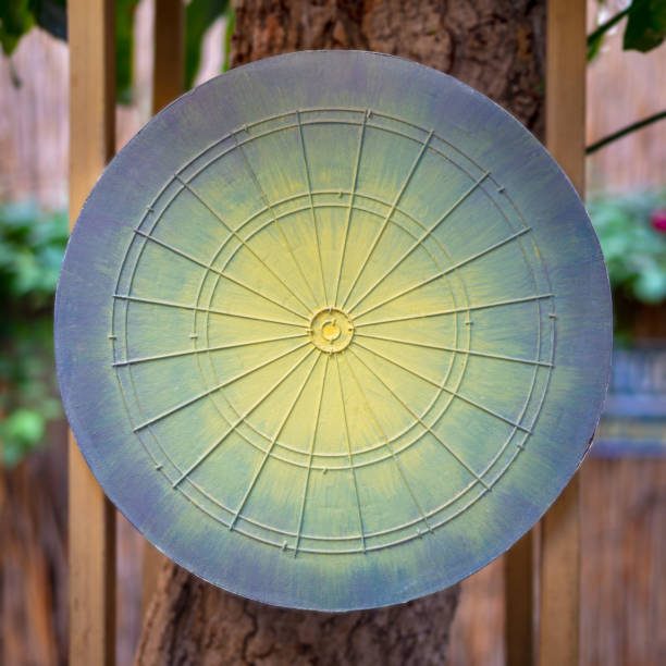 istock Dartboard game board painted in green, yellow and blue hanged on tree in blurred background 951044814