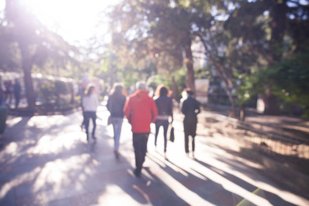 istock Blurred street view with people and trees 951047254