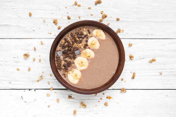 istock chocolate banana protein smoothie bowl with granola. top view 951050868