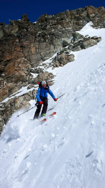 mężczyzna ekstremalnych narciarzy na nartach w dół bardzo strome couloir w głębokiej zimy w alpach szwajcarskich w pobliżu klosters - silvretta zdjęcia i obrazy z banku zdjęć