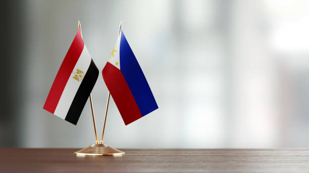istock Egyptian And Philippines Flag Pair On A Desk Over Defocused Background 951054768