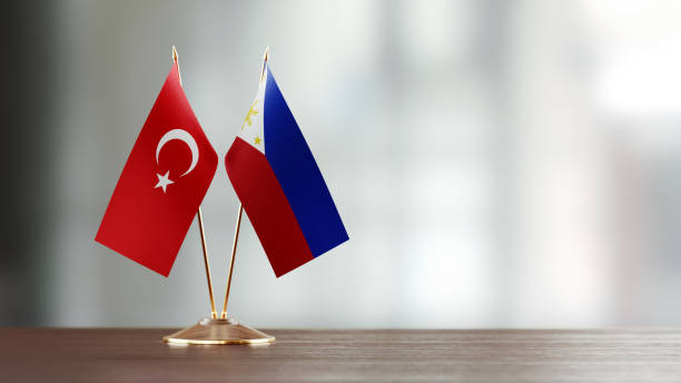 istock Turkish And Philippines Flag Pair On A Desk Over Defocused Background 951055452