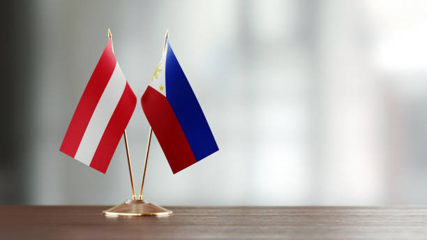 istock Austrian And Philippines Flag Pair On A Desk Over Defocused Background 951055612