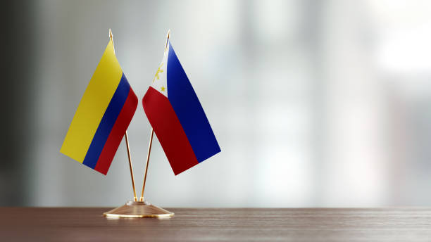 istock Colombian And Philippines Flag Pair On A Desk Over Defocused Background 951055766