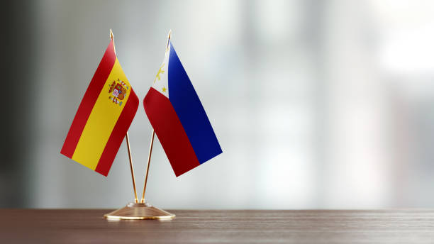 istock Spanish And Philippines Flag Pair On A Desk Over Defocused Background 951056022