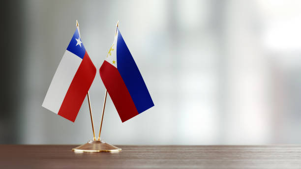 istock Chilean And Philippines Flag Pair On A Desk Over Defocused Background 951056440