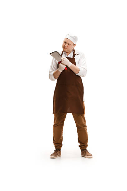 istock Bored butcher posing with a cleaver isolated on white background 951056592
