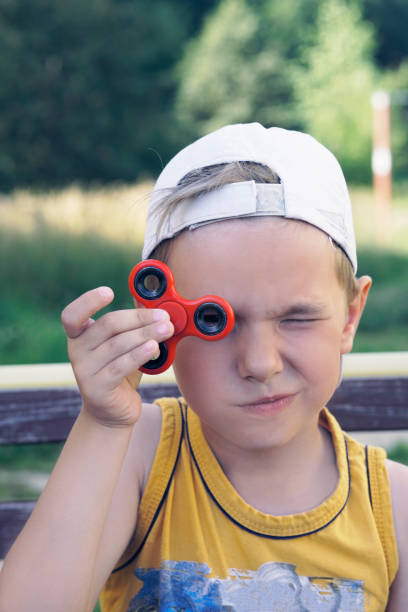 istock Young boy play with fidget spinner stress relieving toy 951059334