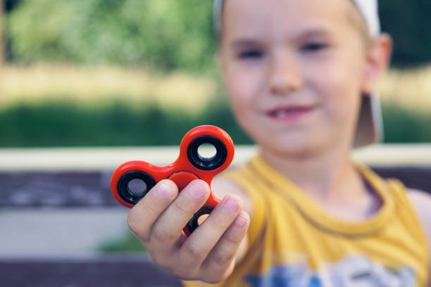 istock Young boy play with fidget spinner stress relieving toy 951059336