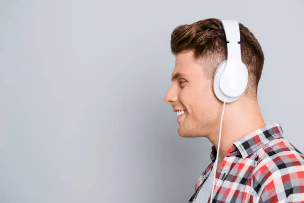 Photo of Side view portrait of handsome smiling man in headphones