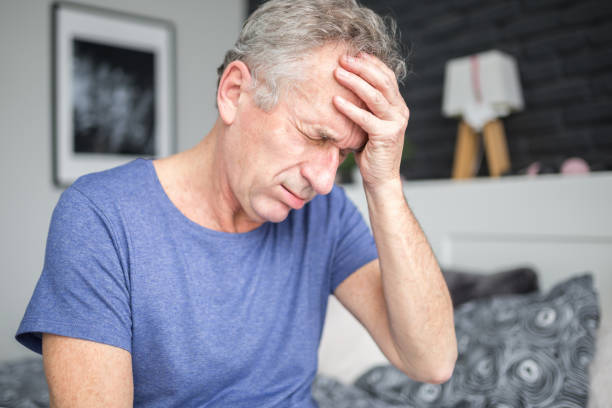 istock Senior man with migraine holding hand on forehead 951059378