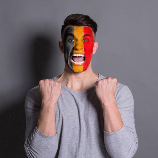 istock Young man with Belgium flag painted on his face 951059446
