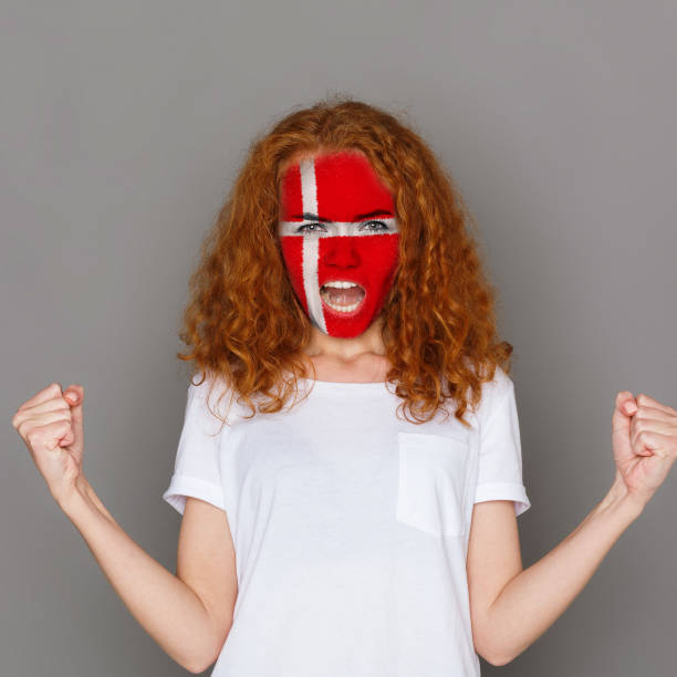 istock Young woman with Denmark flag painted on her face 951059502