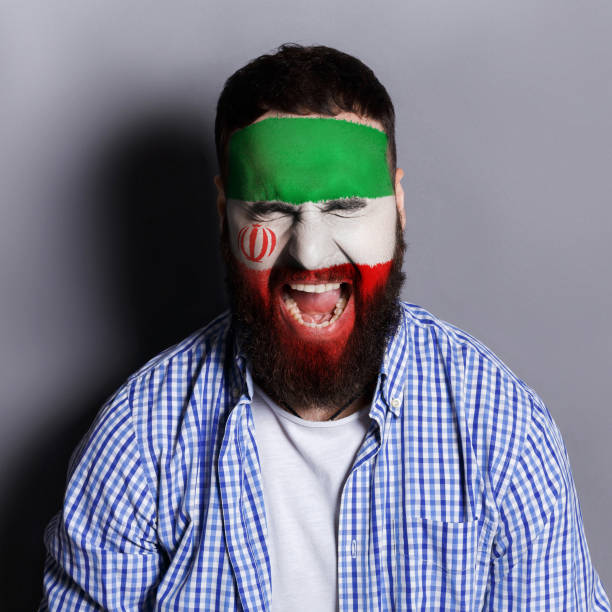 istock Young man with Iran flag painted on his face 951059578