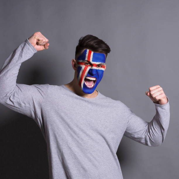 istock Young man with Iceland flag painted on his face 951059592
