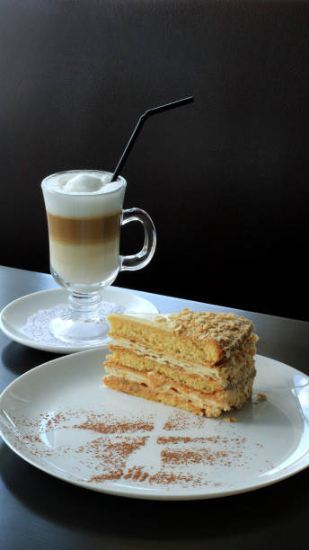 Sweet puff pastry Napoleon cake and milk coffee on the bar table at cake shop