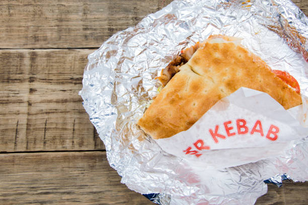istock Turkish kebab on a wooden table wrapped in foil is copy space 951059874