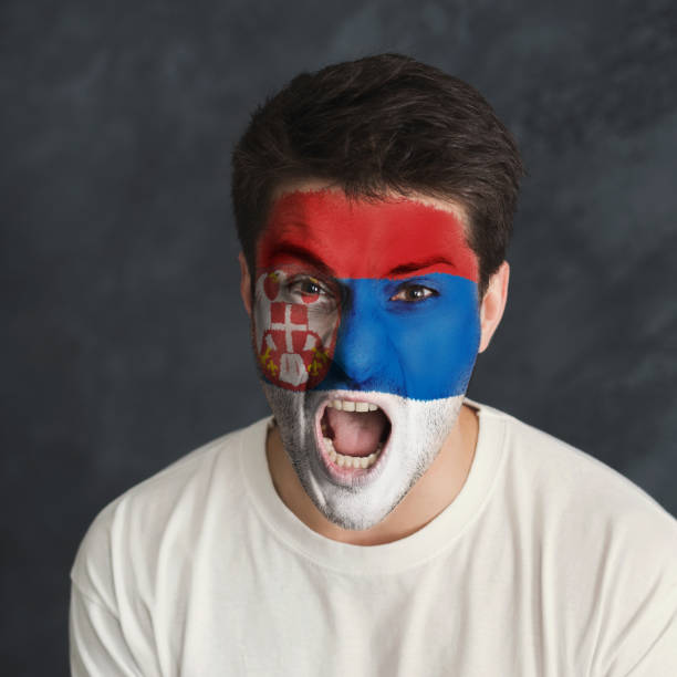 istock Young man with Serbia flag painted on his face 951059878