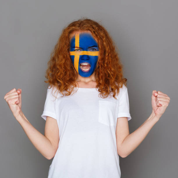 istock Young woman with Sweden flag painted on her face 951059934