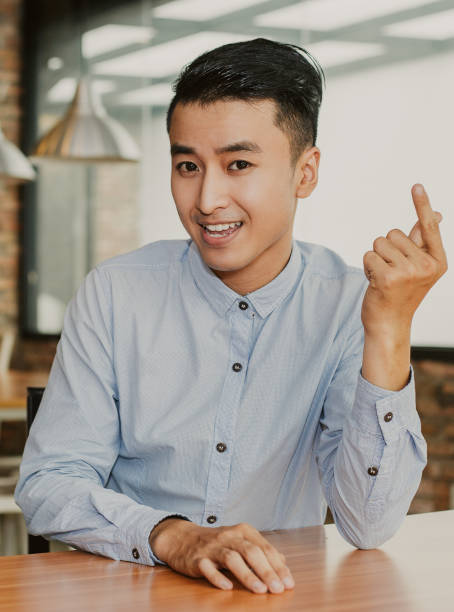 istock Positive Asian Man Gesturing and Talking in Cafe 951061836