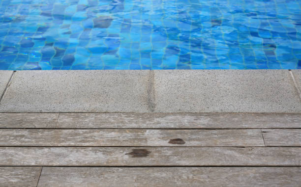 istock Swimming pool with a stone and wooden plank flooring. 951067974