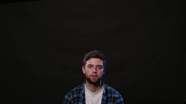 istock A Young Man Mimicing Against a Black Background 951074078