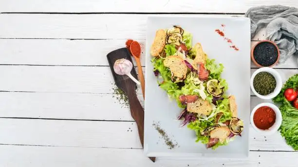 Caesar salad with salmon. Top view. On a wooden background. Copy space.