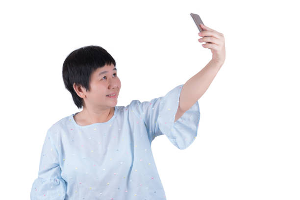 istock Asian Middle-aged woman taking selfies isolated on white background 951077504
