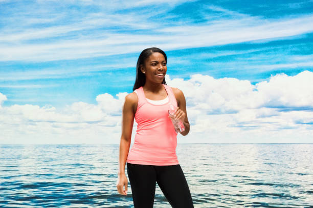 Cheerful female standing by the lake / ocean