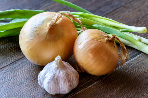 istock Garlic and onions on wooden background 951087530