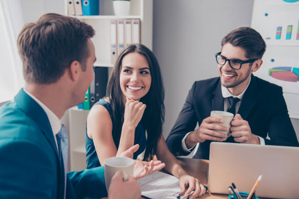 istock Cheerful office workers  discussing their project over cup of tea 951087774