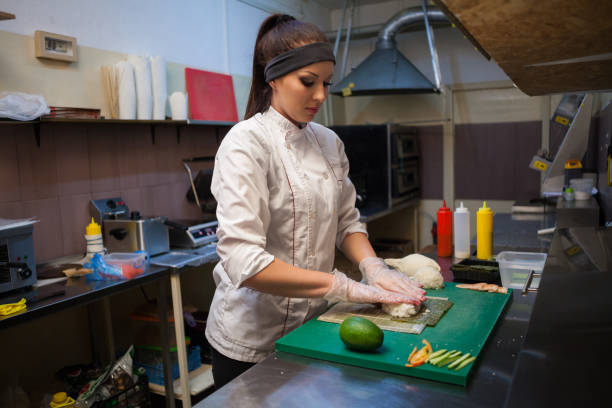 istock woman in white chef prepares sushi restaurant 951087860