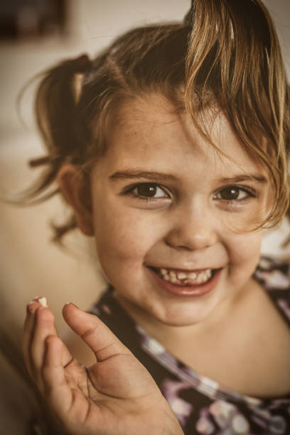 istock Cute little girl showing missing teeth. Looking at camera. 951087922