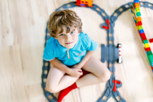 istock little blond kid boy playing with colorful plastic blocks and creating train station 951087992