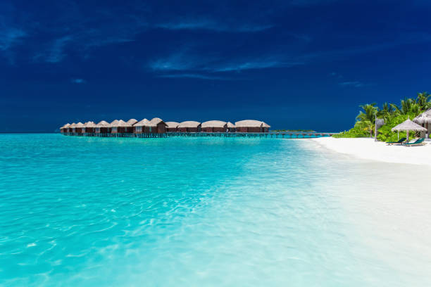 istock Overwater bungallows in blue lagoon on tropical island 951088252
