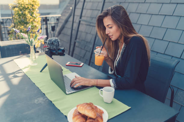 donna sulla terrazza panoramica che fa colazione durante il vlogging - balcony women patio coffee foto e immagini stock