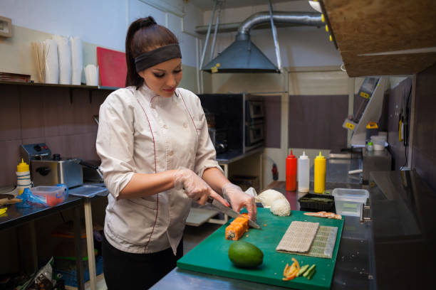 istock woman in white chef prepares sushi restaurant 951090262