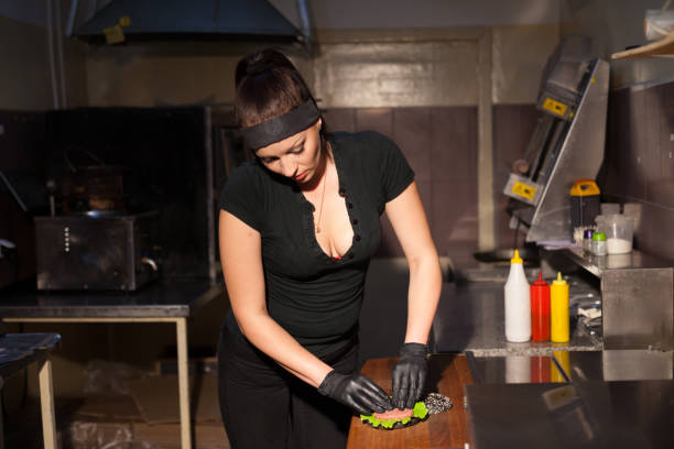 mujer en negro chef prepara una hamburguesa en un restaurante - white food and drink industry hamburger cheeseburger fotografías e imágenes de stock