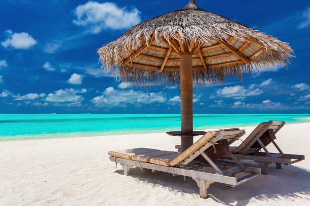 istock Two chairs and umbrella on a tropical beach with amazing lagoon 951090682