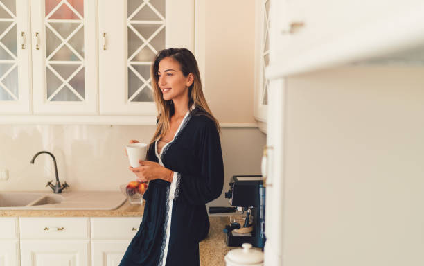 istock Smiling woman in the kitchen enjoying a coffee cup 951090780
