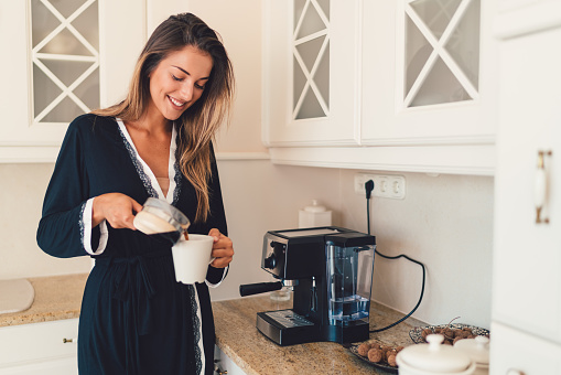 Young woman in the kitchen enjoying a cup of coffee