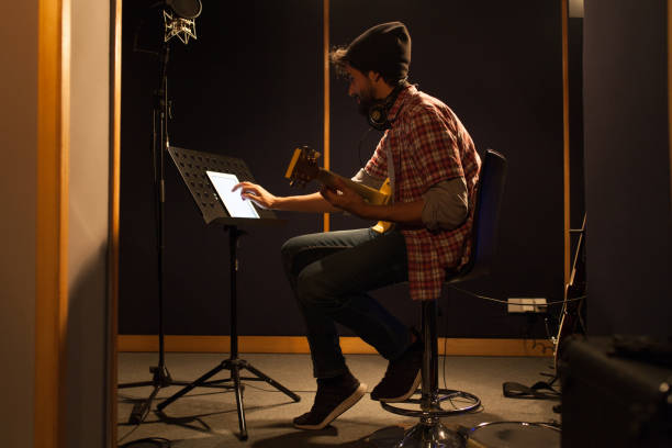 istock Attractive guitarist playing a guitar in music studio 951091484