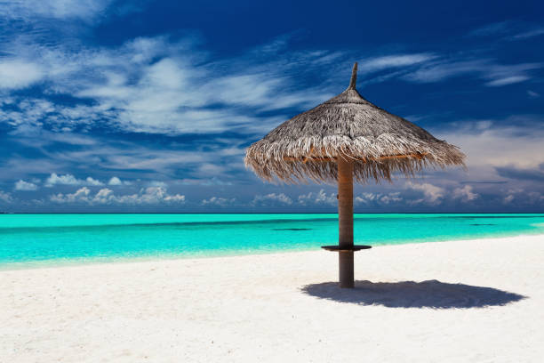 istock Single tropical beach umbrella on romantic white beach 951091614